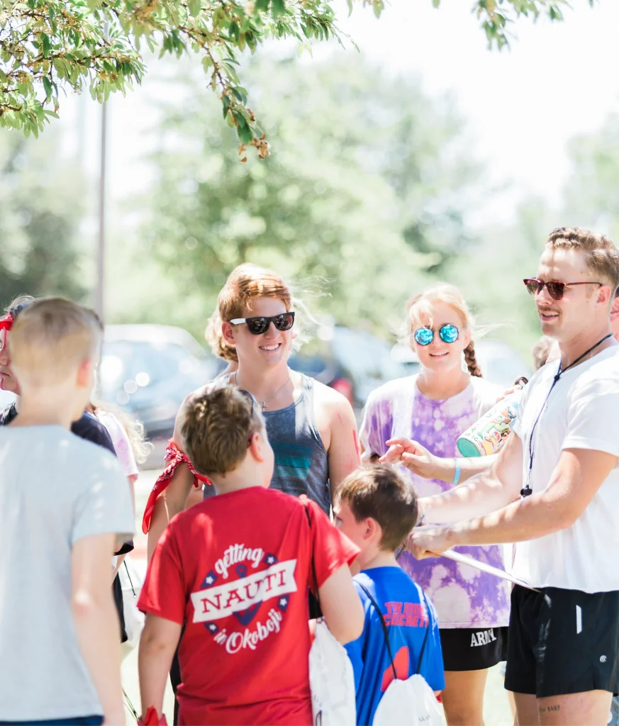 creating welcoming student ministry spaces | enviropop | image features a team leader/pastor with kids engaging in conversation making them feel welcomed