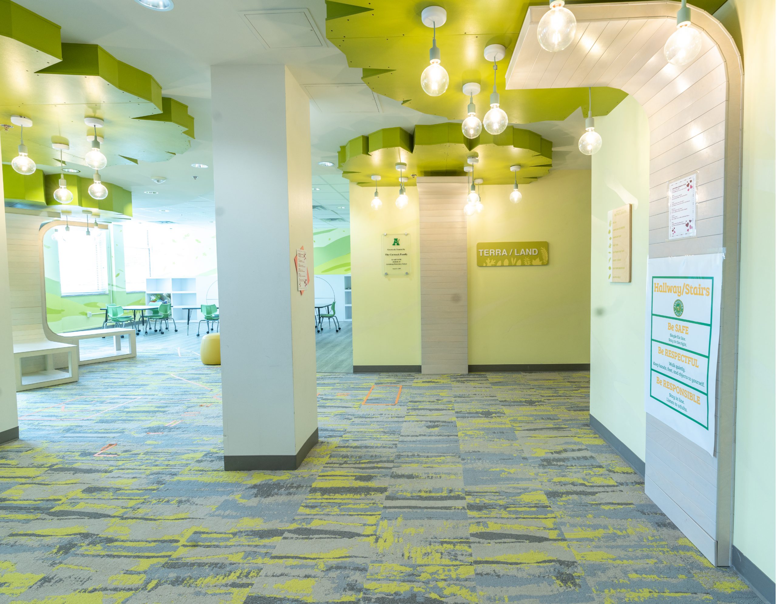 Dimensional tree architectural feature with leaf canopy ceiling design in the Terra/Land zone hallway at Armstrong Elementary by Enviropop