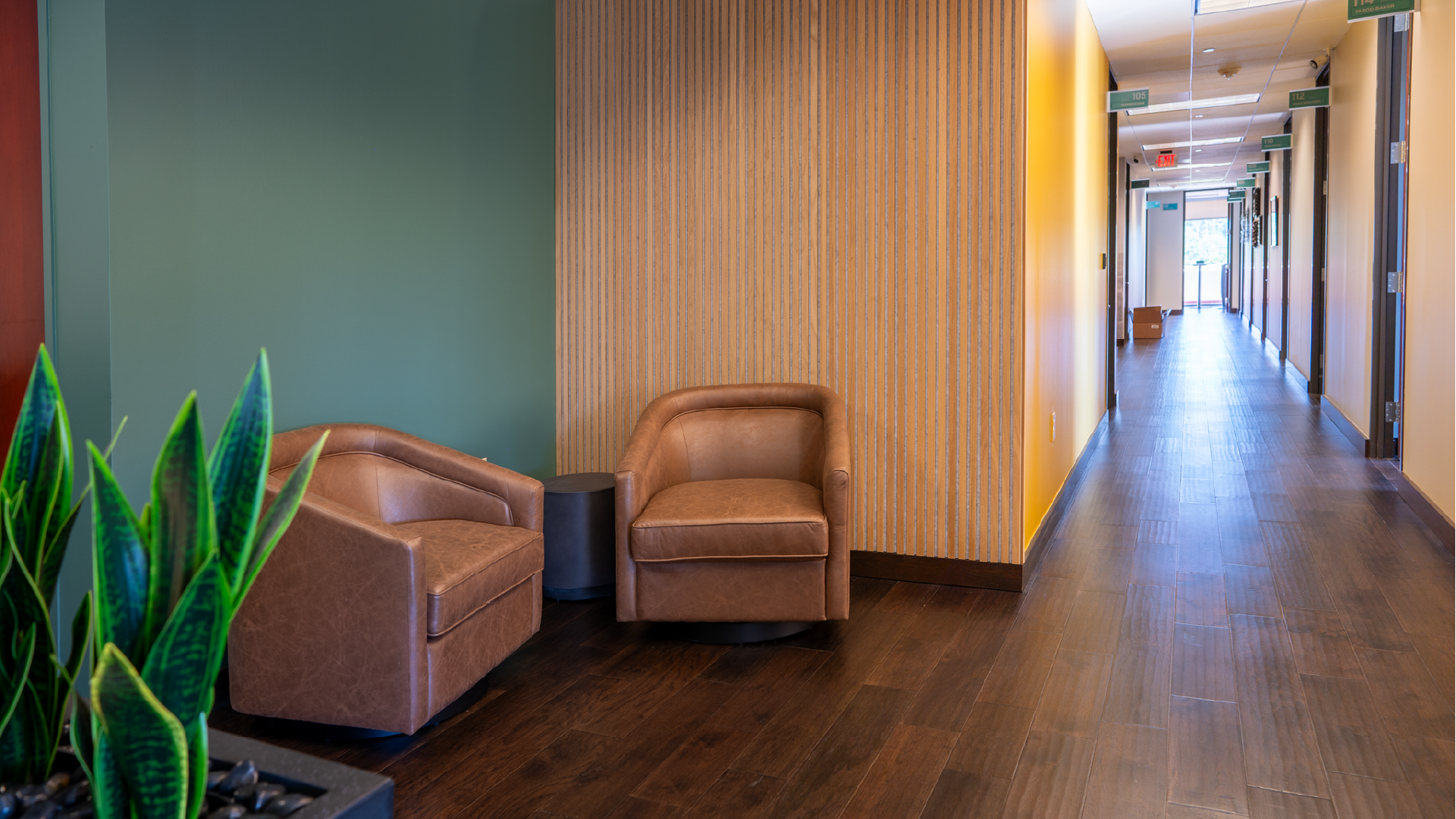 interior design for benefit architects - enviropop helped pick out paint color & wood acoustic wall panels for the walls along with two brown leather chairs and end table for guests or employees to sit