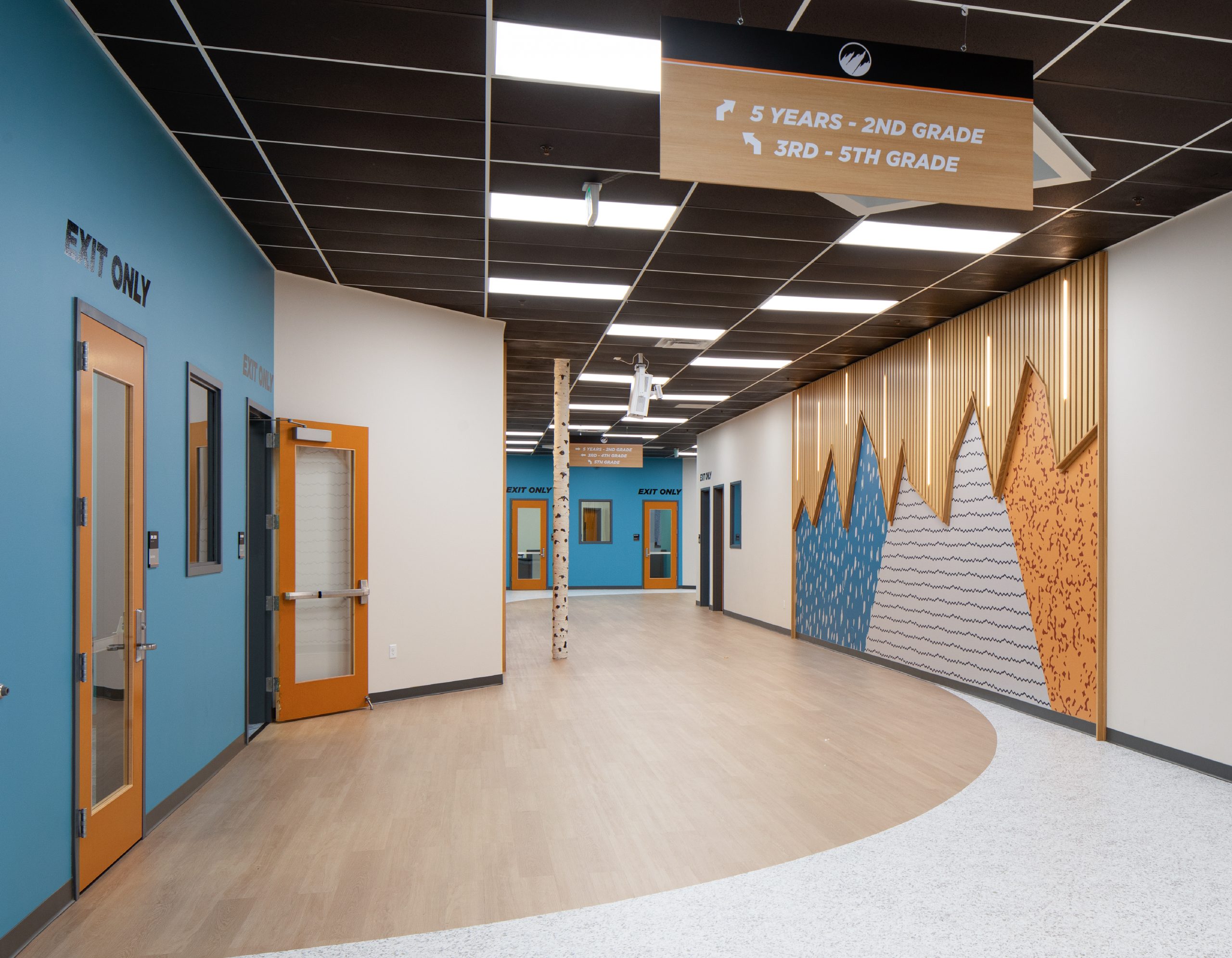 Flatirons church kids hallway with environmental graphic design mountain mural and wayfinding signage for grade-level classrooms