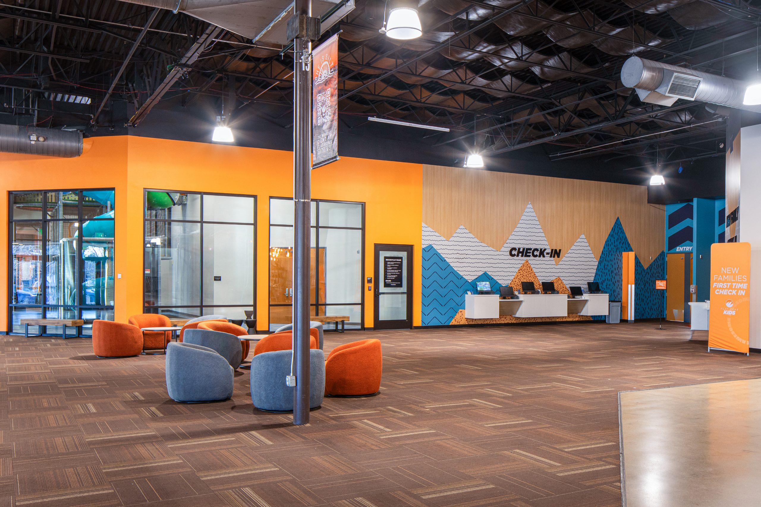 Flatirons church check-in lobby with branded wall design, mountain supergraphic, and interior wayfinding signage