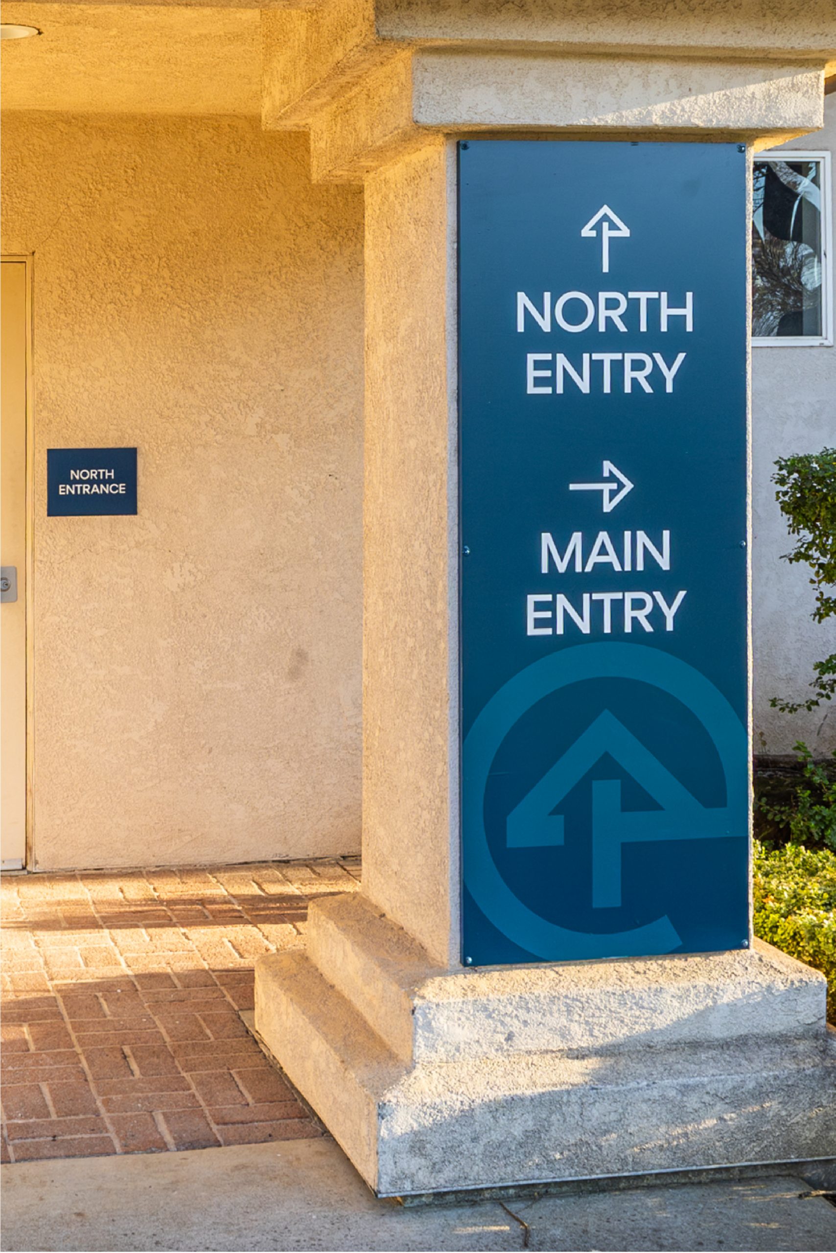 Exterior wayfinding signage directing visitors to North Entry and Main Entry at Evangelical Free Church of Chico